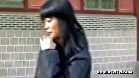 Seductive Korean woman in black coat posing outdoors by temple