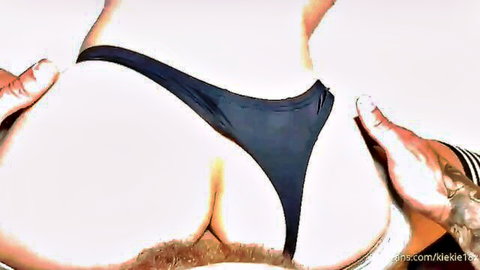 Tattooed hands spreading pale ass cheeks exposing hairy anus and pink pussy with black thong pulled aside