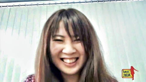 Smiling Asian woman with long brown hair and bangs in red top