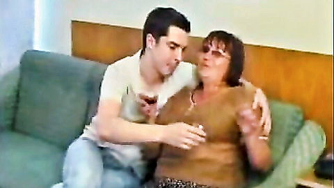 Young man embraces older BBW mom's friend intimately on couch