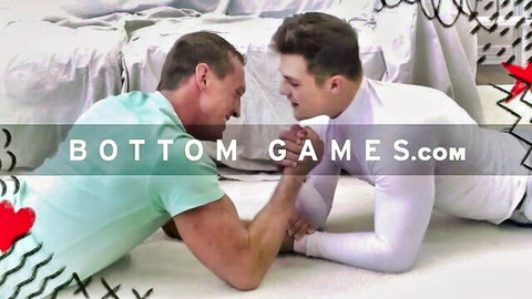 Two muscular gay hunks in shirts arm wrestle intensely on white carpet for Bottom Games