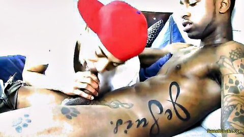 Tattooed black stud gets blowjob from guy in red hat
