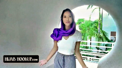 Asian hijab girl in white top gray pants purple scarf posing seductively outdoors