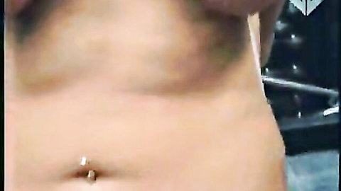 Hairy muscular man torso with navel piercing in dark BDSM dungeon