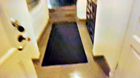 Empty indoor hallway entrance with black doormat white doors and cabinets