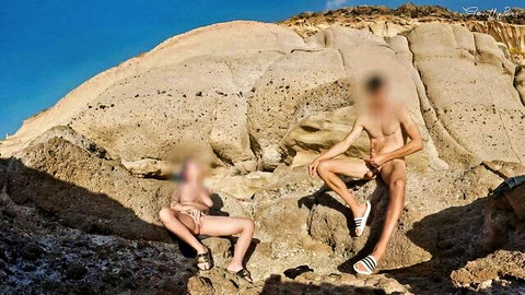 Risky public handjob: blonde woman strokes naked stranger's cock outdoors on rocks