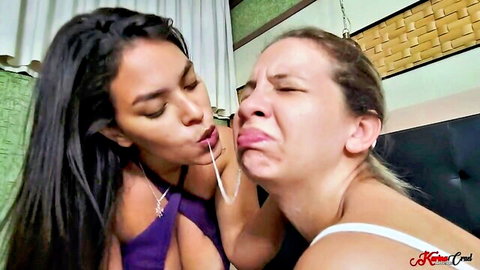 Two busty Latinas passionately French kissing with tongues out and puckered lips