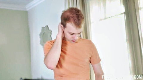 Alex Jett in orange t-shirt, intense expression in bedroom with Hazel Heart