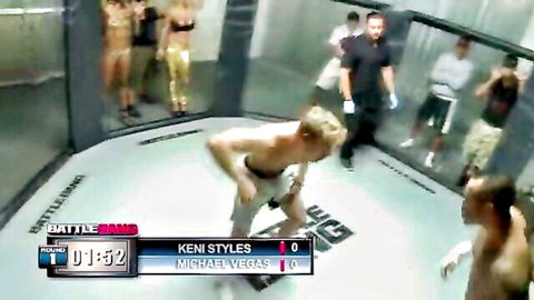 Kenny Styles bent over facing Michael Vegas in intense Battle Bam octagon fight with sexy women watching