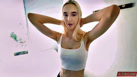 Skinny blonde teen with medium tits stretches arms up in tight white tank top POV