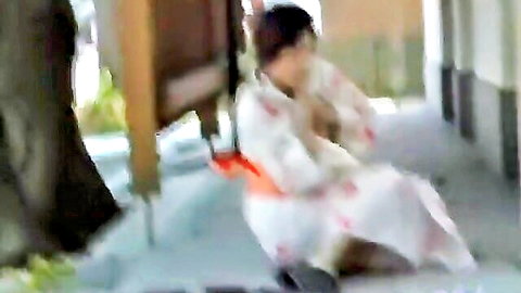 Naughty Japanese woman in white kimono sitting teasingly on outdoor porch