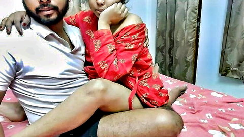 Intimate Indian couple embracing in red floral dress on bed