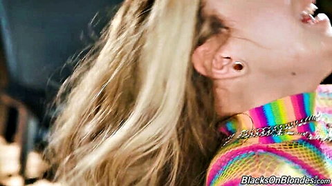 Ecstatic blonde in shiny rainbow chainmail top with open mouth gasping in pleasure