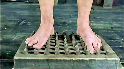 Young blonde slave's bare feet tortured on spikes in BDSM basement scene