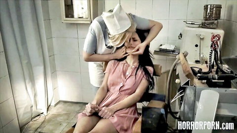 Bizarre brunette with big tits in pink dress toyed by nurse in horror porn