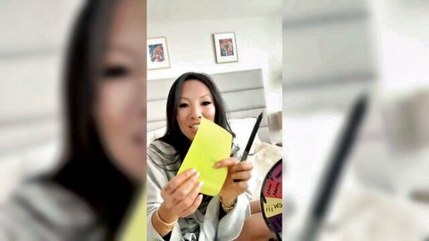 Asian MILF Sayoko Kuroki holding yellow card and pen in teasing pose