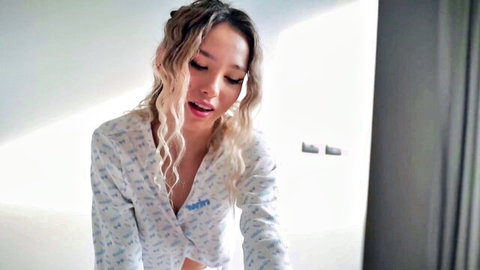 Sensual Russian beauty in revealing white pajamas, teasing with cleavage and curves