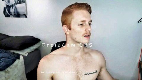 Shirtless freckled redhead with chest tattoo teases on gay webcam