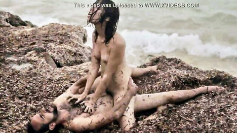 Nude movie stars in steamy outdoor cowgirl sex on rocky beach