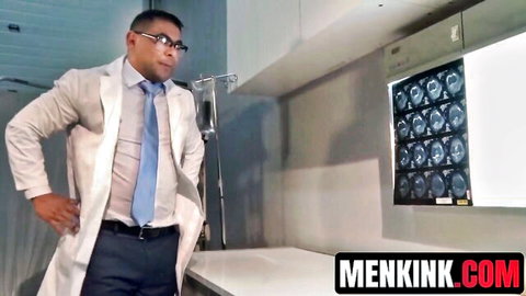 Muscular doctor in open white lab coat and tie standing in exam room with x-rays