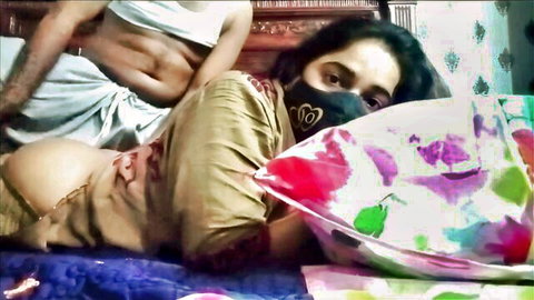 Seductive busty Indian mature babe in low-cut saree blouse exposing deep cleavage on bed with man