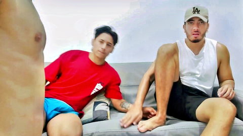 Two fit Asian guys in shorts chilling casually on couch