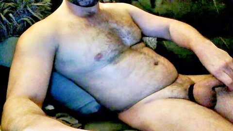 Hairy mature man with beard exposes erect cock and cock ring in solo amateur pose