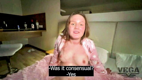 Vincent Vega in open pink satin robe exposing perky breasts on bed