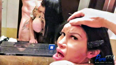 Latina trans beauty with mouth wide open for rough deepthroat blowjob, hand gripping hair in steamy bathroom.