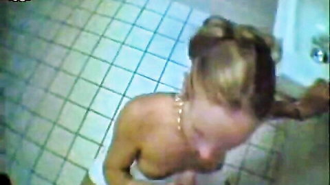 Tattooed blonde cutie topless in toilet, natural tits exposed