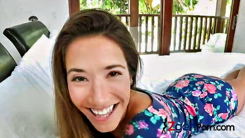 Eva Lovia smiling in floral dress on bed, teasing threesome with Kiera King