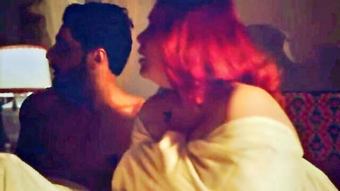 Redhead woman in slipping white robe teases shirtless bearded man on bed