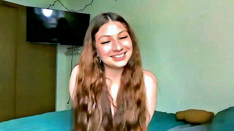 Petite brunette webcam model smiling topless with bare tits in bedroom