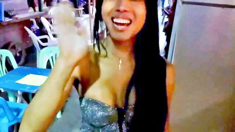 Smiling Asian ladyboy in sparkly dress showing cleavage, waving seductively