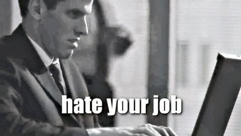 Frustrated man in suit typing on laptop with 'hate your job' text overlay