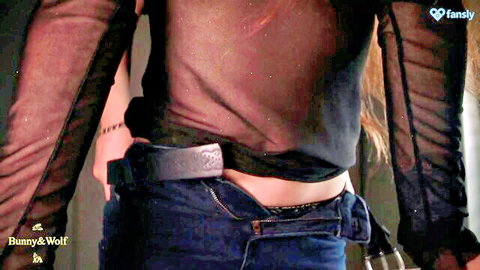 Dominant woman in sheer black top and low-rise jeans, ready to dominate