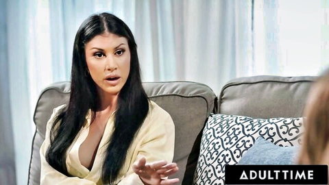 Brunette with deep cleavage in open yellow top gesturing surprised on couch