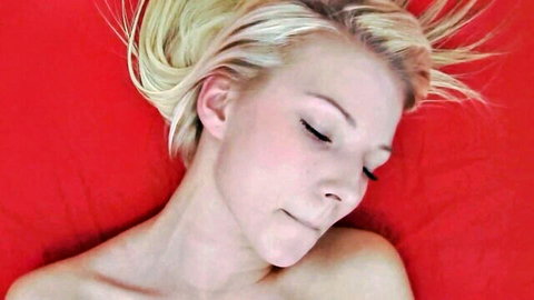 Blonde tattooed amateur babe topless, eyes closed in ecstasy on red sheets