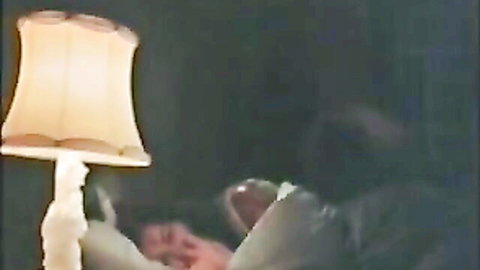 Vintage MILF redhead seduces young stud in dimly lit bedroom romp
