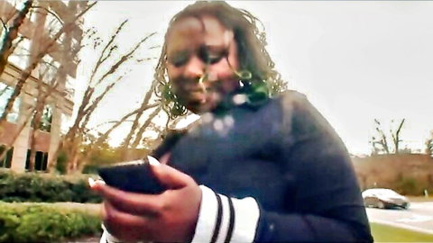 Ebony model Poizon Ivy in casual outdoor tease, holding phone