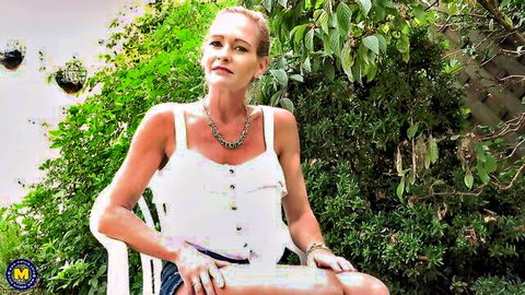 Blonde MILF in white tank top relaxing in backyard, huge tits visible