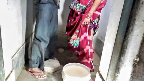 Desi woman in red saree with man in intimate doorway pose