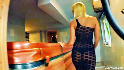 Blonde MILF in sheer black dress walking outdoors, teasing for threesome