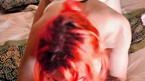 Close-up POV of tattooed redhead in white top for intimate ASMR session
