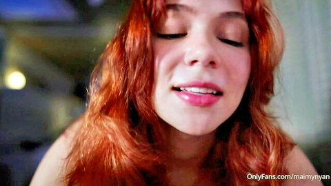 Redhead beauty with glossy parted lips smirking seductively in close-up POV tease