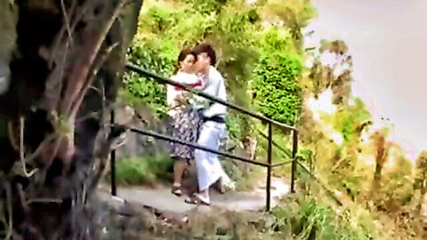 Hot MILF in white dress embraced by man outdoors on family trip path
