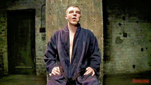 Muscular blonde man in open purple robe in BDSM scene