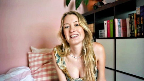 Blonde Emily smiling in low-cut dress showing cleavage for ASMR