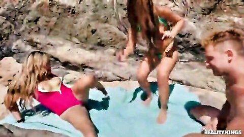 Katy Jayne and busty friends in bikinis tease on rocky beach with hunk