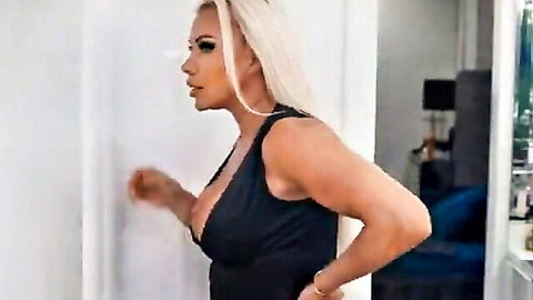 Robbin Banx in low-cut black dress, blonde hair, deep cleavage tease